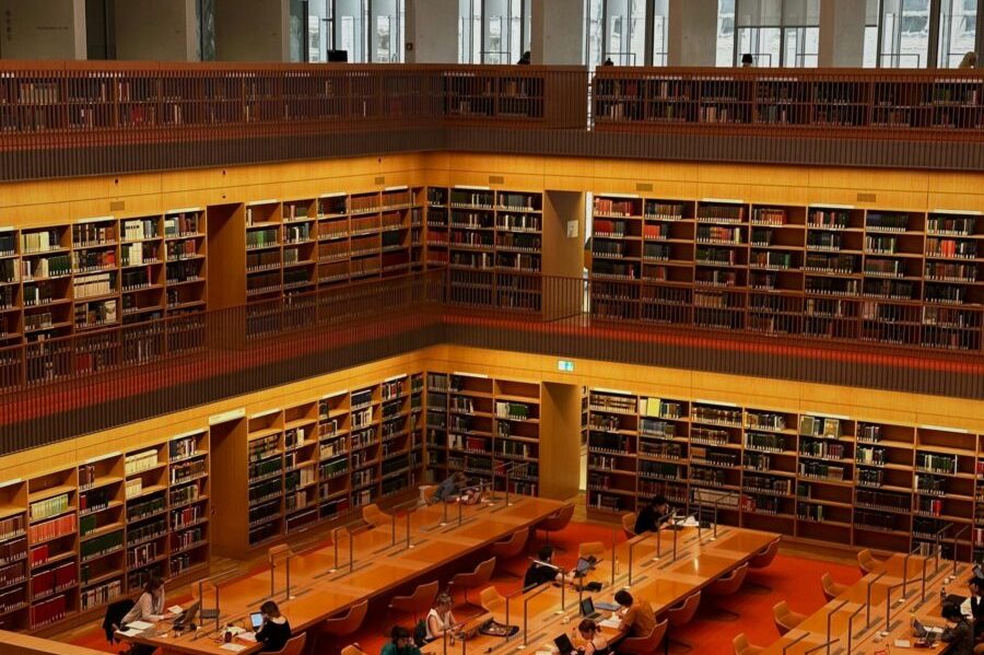 Vibrant interior of a multi-level library in Berlin with people studying.